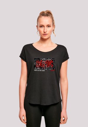 Black short-sleeve t-shirt with a rounded neckline, featuring a graphic print with red and white text "AC/DC SHOT IN THE DARK" against a black background.