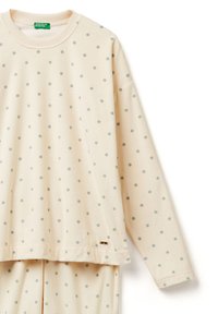 Lichtbeige sweatshirt met grijze stippen, met een ronde hals en lange mouwen. Zachte textuur met een kleine gouden accent aan de zoom.