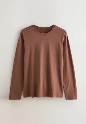 Langärmliges Hemd aus braunem Baumwollstoff mit Rundhalsausschnitt, lässiger Passform und glatter Textur ohne auffällige Muster oder Akzente.