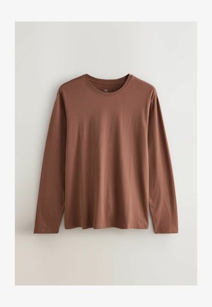 Camisa de manga larga de tela de algodón marrón, con escote redondo, corte relajado y textura suave sin patrones o acentos prominentes.