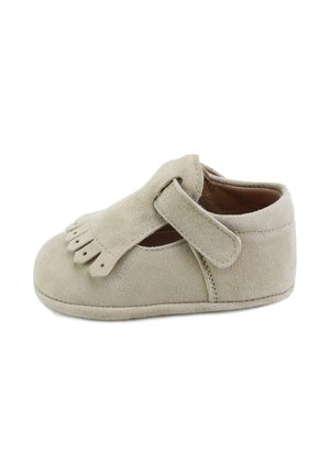 Zapato de bebé de ante beige con solapa con flecos y cierre de tira de velcro, suela blanda, diseñado para comodidad y fácil uso.