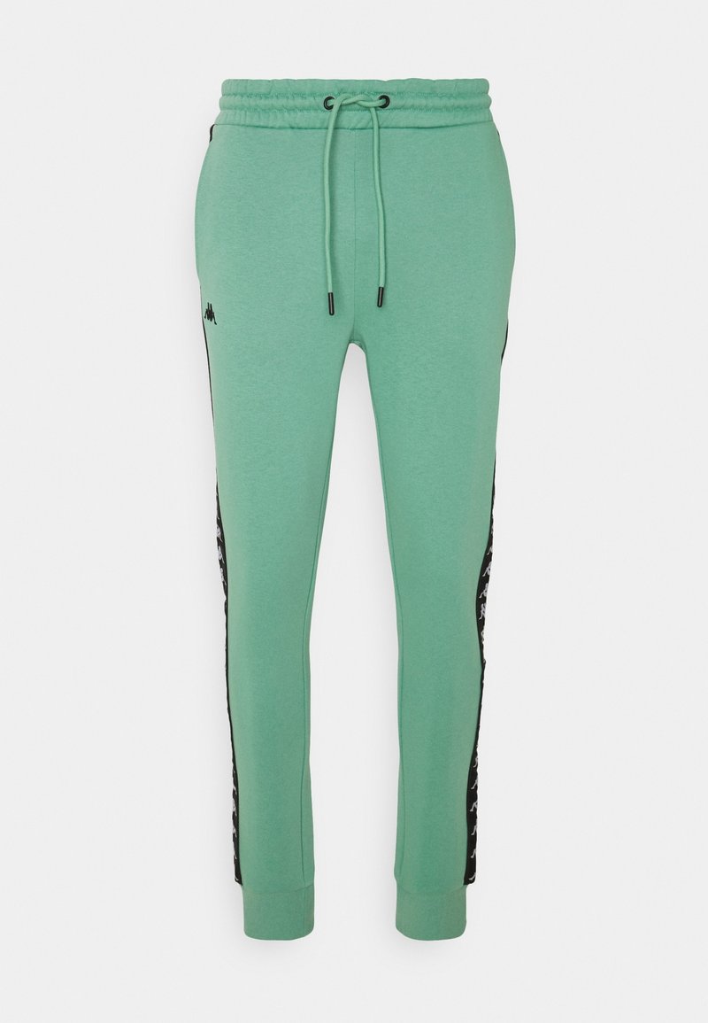 Mint green joggers with an elastic waistband, drawstring, and black side panels featuring a repeated logo pattern. Soft cotton blend fabric.