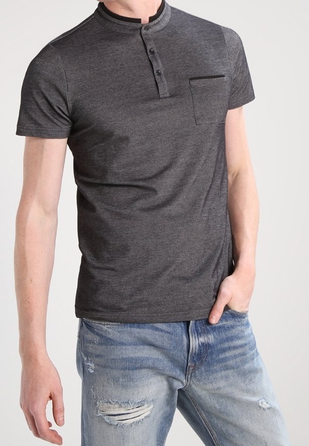 Polo à manches courtes gris foncé avec un col à bouton-pression, doté d'une poche poitrine et d'un tissu doux, associé à un jean clair déchiré.