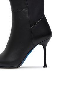 Stivale nero con tacco alto realizzato in pelle e tessuto, caratterizzato da un design elegante, punta affusolata e un accento blu sulla suola.