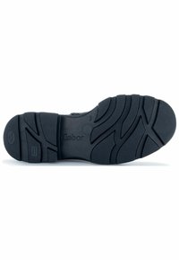 Black rubber shoe sole with textured surface, featuring grooves and ridges for grip. Gabor logo embossed on the heel area.