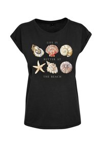 Juoda trumpa rankovė t-shirt su įvairiomis jūros kiautų grafikomis ir tekstu "Gyvenimas yra geresnis prie jūros" kreminės spalvos raidėmis.
