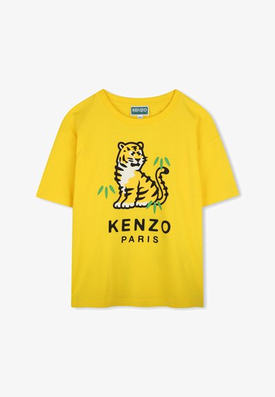 T-shirt en coton jaune avec un graphisme de tigre noir et orange, agrémenté de accents verts et "KENZO PARIS" imprimé en dessous. Manches courtes, coupe décontractée.