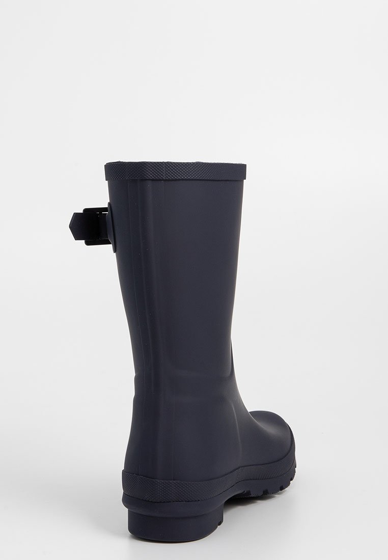 Botas de lluvia de goma en color navy con una parte superior texturizada, diseño sólido, eje recto y una lengüeta en la parte trasera para facilitar el uso.