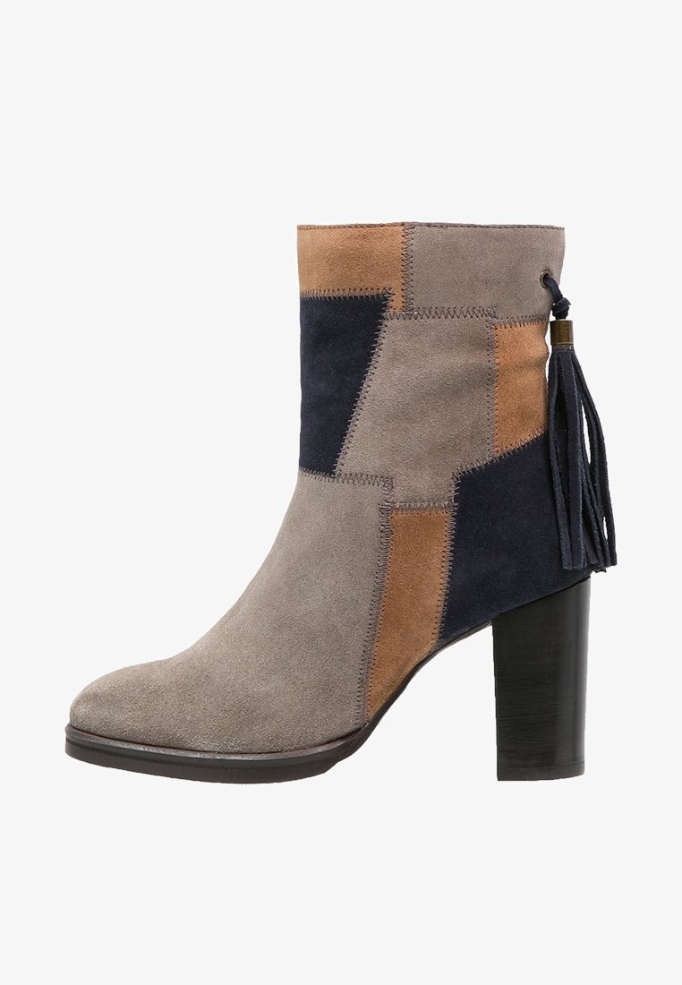 Bottine en daim avec un talon bloc, présentant un design en blocs de couleur gris, beige et marine ; comprend un accent à pampille sur le côté.