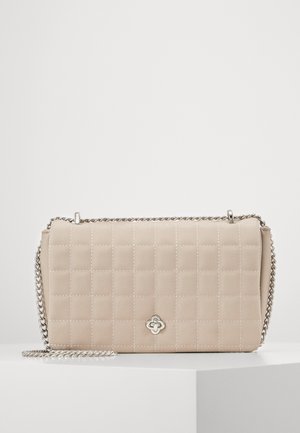Sac à main beige matelassé avec une bandoulière en chaîne, présentant un accent logo argenté à l'avant et une forme rectangulaire. Matériau lisse et texturé.
