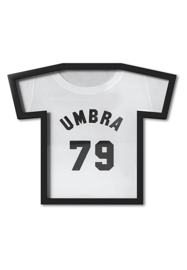 Rahmenkunst im Schattenkasten in Form eines T-Shirts. Weiße Stofffläche mit schwarzen Zahlen "79" und dem Text "UMBRA" in gekrümmter Anordnung. Schwarzer Rahmen.