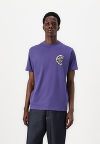 Purple cotton t-shirt with short sleeves, featuring a circular "Santa Cruz" logo on left chest in black and white. Plain design.