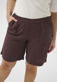Bermuda bordó dalam kain ringan dengan pinggang elastis dan kantong samping, menampilkan potongan santai dan hem lurus.