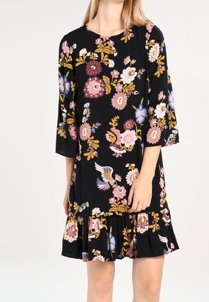 Sort knælang kjole med pink, gult og blå blomster- og fuglemønstre, med 3/4 ærmer og en flæsekant.