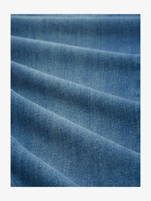 Denim-kangas, jossa on sileä rakenne; keskitason sininen väri, jossa on hienovaraisia vaihteluita. Sisältää vinoa kudontakuviota ja kevyttä kiiltoa kankaan pinnasta.