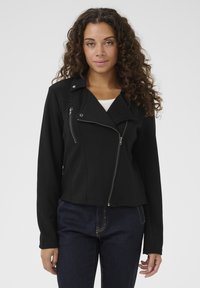 Svart motorcykeljacka med en figurnära design, dragkedjefickor och asymmetrisk framdragkedja. Tillverkad av ett slätt tyg med en strukturerad look.