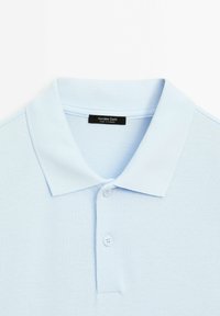Light blue polo shirt with a textured fabric, featuring a two-button placket and a ribbed collar. Label visible reads "Massimo Dutti."