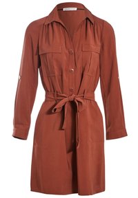 Robe-chemise à manches longues couleur rouille, avec fermeture boutonnée à l'avant, deux poches poitrine et une ceinture nouée à la taille.
