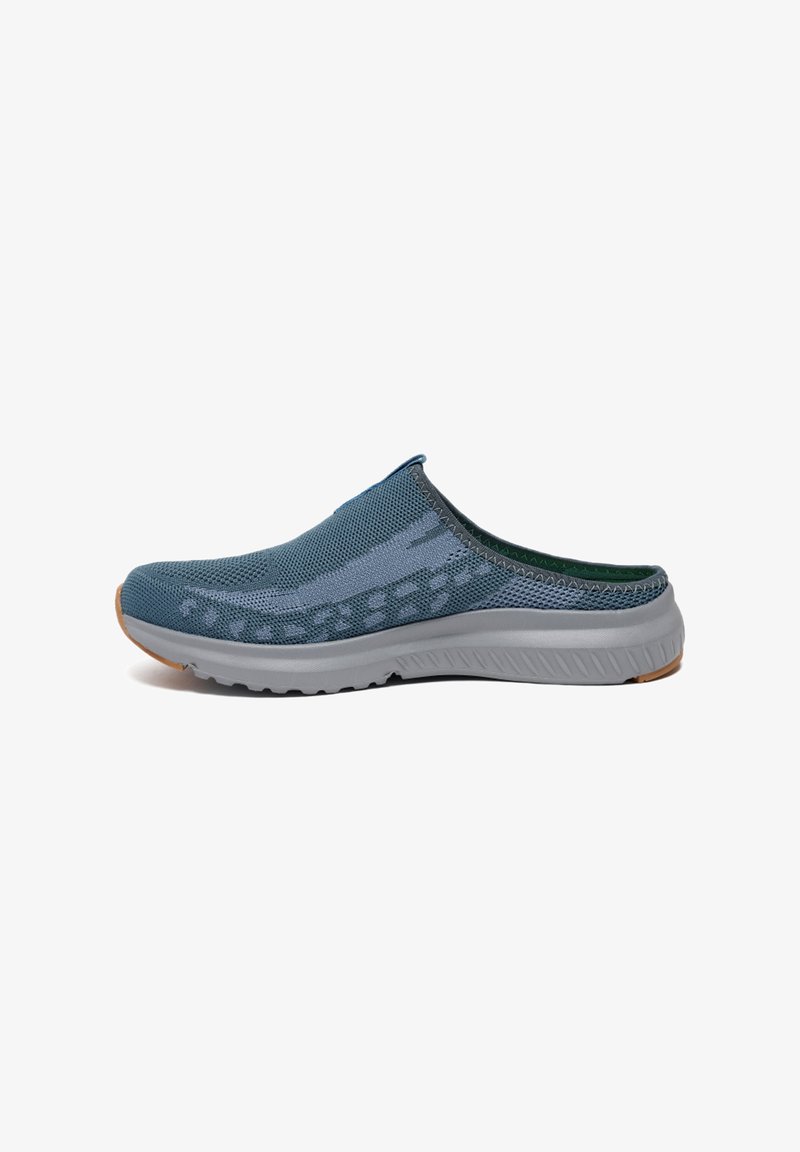 Chaussure slip-on en maillage bleu foncé, dotée d'une semelle légère grise, de motifs texturés sur l'empeigne et d'une doublure verte.
