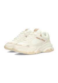 Zapatillas deportivas blancas con detalles en beige, paneles de malla, cuello acolchado y suela de goma texturizada con un patrón ondulado. Los cordones son blancos.