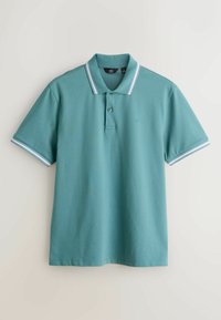 Polo turquoise à manches courtes, patte à deux boutons, col et poignets de manches rayés contrastants. Logo brodé sur la poitrine.