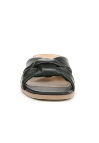Sandale en cuir noir à enfiler avec un design de dessus noué, bout ouvert rectangulaire et une semelle plate beige. Texture lisse et accents minimalistes.