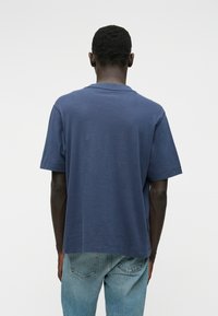 Ναυτικό μπλε κοντομάνικο μπλουζάκι με άνετη εφαρμογή, φτιαγμένο από μαλακό υλικό. Διαθέτει στρογγυλή λαιμόκοψη και λεία υφή. Καθαρά σχεδιασμένο για καθημερινή χρήση.