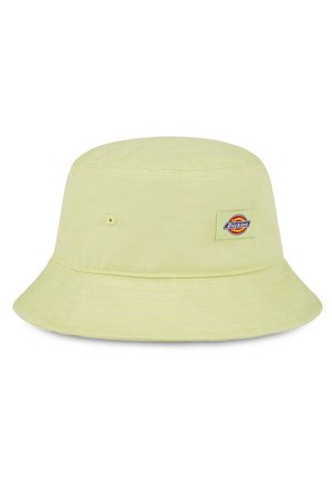 Lys gul bøttehatt laget av bomull med flat krone, bred brem, og et lite logo-patch med et sirkulært design foran.