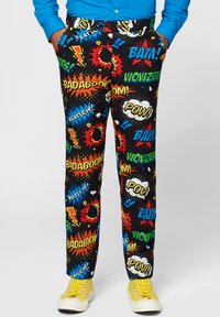 Black pants featuring a vibrant comic book print with bold words like "BAM!" and "POW!" in yellow, red, and blue, paired with yellow sneakers.