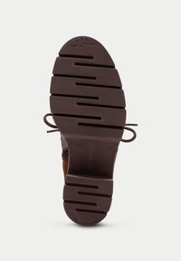Stivale in suede marrone con suola in gomma texturizzata, caratterizzato da un motivo a scanalature unico, lacci profilati e branding in rilievo. Taglia 37.