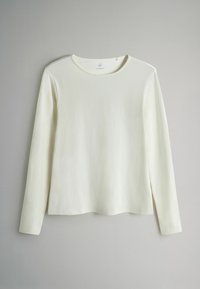 Bluză cu mâneci lungi și decolteu rotund, realizată dintr-un material moale, ușor, de culoare ivoriu, cu textură netedă și tiv ușor curbat. Design minimalist.