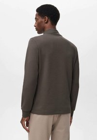 Sudadera gris oscuro con cuello alto, mangas largas y textura suave; presenta un diseño minimalista y detalles de costura sutiles.
