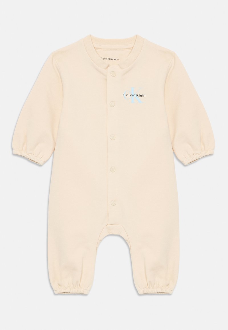 Beige bomull baby jumpsuit med lange pufferm, trykknapper foran, og en fargerik Calvin Klein-logo på brystet.