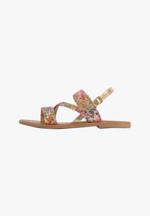 Sandales plates tissées avec des brides multicolores en rose, doré et argenté ; dotées d'une boucle dorée et d'une semelle beige.