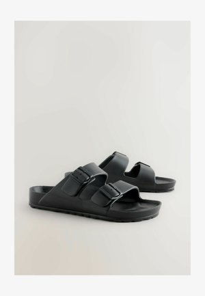 Zwarte schuifsandalen van duurzaam plastic, met twee verstelbare banden met gespen, een gevormde voetbed en een gestructureerde buitenzool.