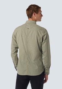 Langarmshirt in het groen met een geometrisch patroon. Voorzien van een button-down kraag en een achterpand met een kleine knoopdetail op de bovenrug.