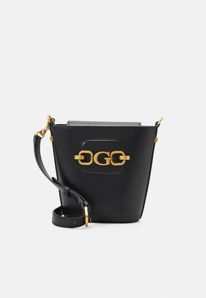 Sorte læder bøtte taske med guld hardware, der har et rundt logo detaljer og en justerbar skulderrem for alsidige bære muligheder.