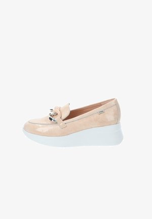 Mocassini con zeppa in morbida pelle verniciata beige, con un fiocco annodato e dettaglio in hardware metallico, abbinati a una suola piatta bianca a contrasto.