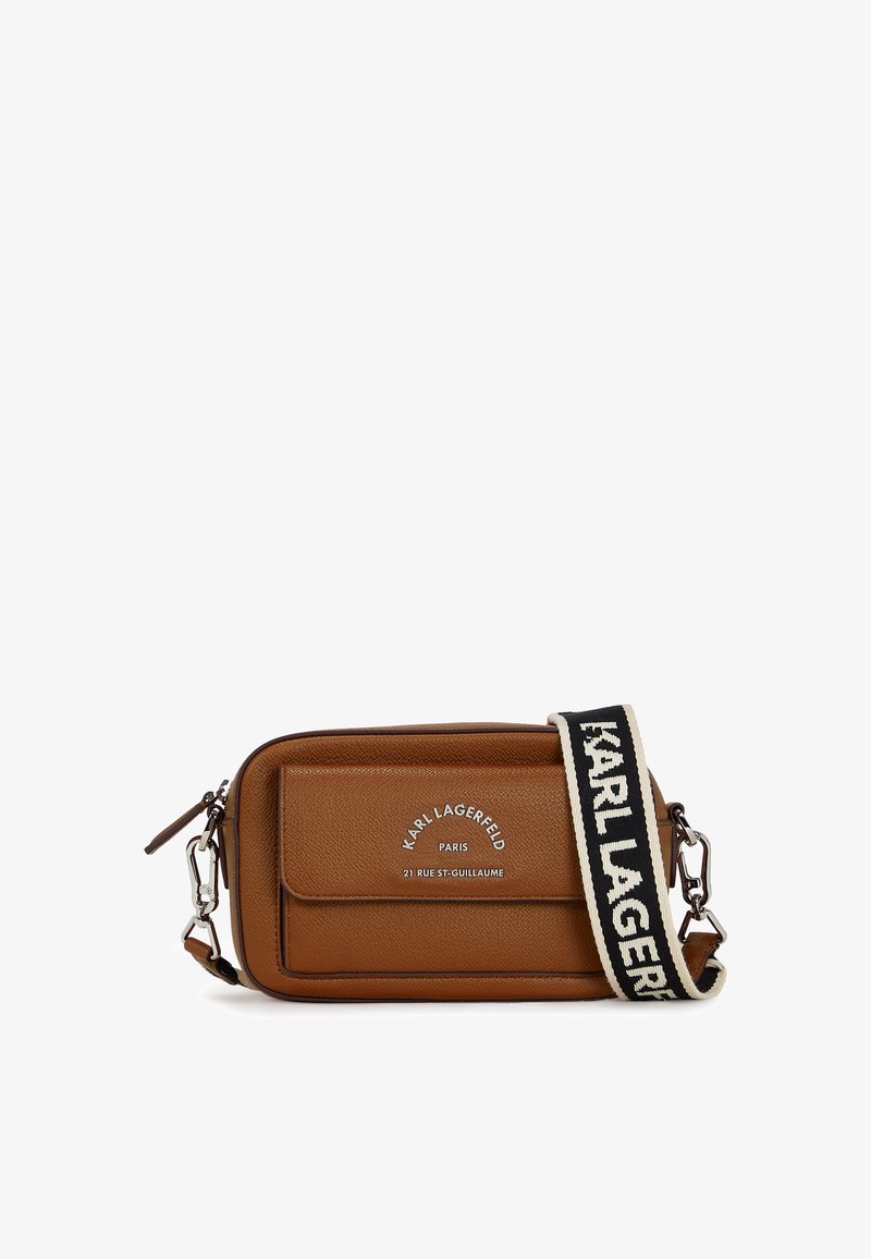 Brun lærcrossbody-veske med glatt tekstur, frontlokk og logo-detalj. Justerbar stropp med kontrasterende svart skrift.