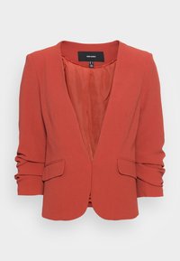 Czerwony żakiet wykonany z teksturowanej tkaniny, z klapami typu notch, dwiema naszywanymi kieszeniami i marszczonymi rękawami. Wykończony gładką podszewką.