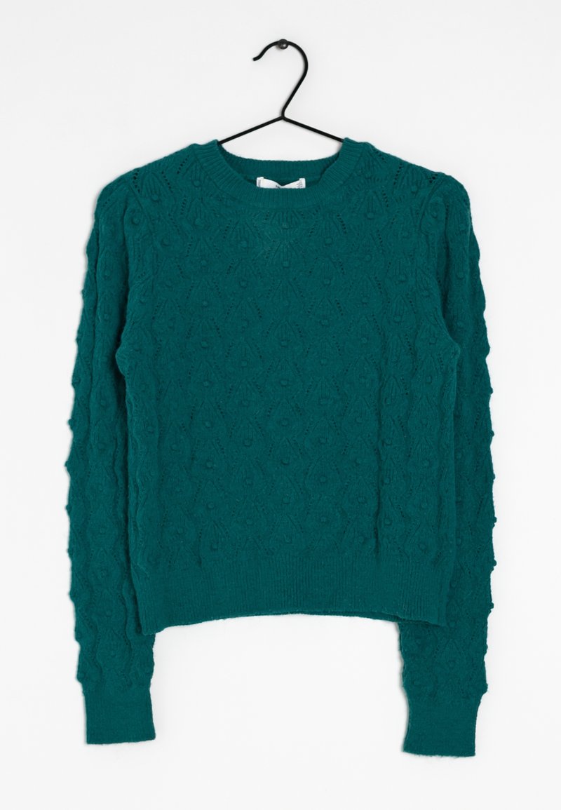 Pull en maille bleu sarcelle à manches longues avec motif diamant texturé, col rond et poignets côtelés, suspendu sur un cintre noir contre un fond blanc.