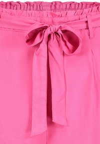 Pink, lightweight fabric with a gathered elastic waist and a tied bow detail at the front. Smooth texture and solid color.