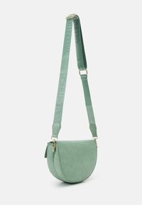 Sac bandoulière en demi-lune en cuir vert menthe texturé avec quincaillerie dorée. Comprend une sangle avec logo et une fermeture à rabat.
