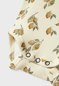 Bodysuit para bebé con estampado floral en tejido de canalé crema, con hojas amarillas y verdes. Incluye cierre a presión en la parte inferior.