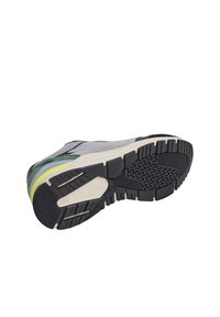 Scarpa sportiva con tomaia grigia, dettagli neri e verdi, intersuola a strati in giallo e blu, e suola in gomma testurizzata con battistrada a motivo.