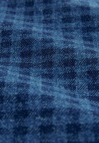 Blau kariertes Gewebe mit einer weichen Textur, das ein Karomuster in verschiedenen Blautönen und subtilen Variationen im Gewebe aufweist.