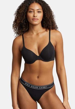 Svart vadderad bh med tunna justerbara axelband, med ribbad textur och en logoband på matchande svart trosa. Mjuk tygfinish.