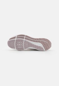 Sportliche Schuhsohle aus helllila und weißem Gummi, mit einer strukturierten, gemusterten Oberfläche für Griff und Stabilität. Detailverliebtes Design.