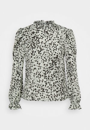 Long-sleeve women's blouse with black irregular spots on light gray fabric, featuring a ruffled high neckline and gathered cuffs.