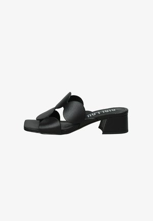 Sandal con tacco alto nero con design a punta quadrata. Presenta tre accenti circolari sovradimensionati sulla fascia superiore, realizzati in materiale dalla texture liscia.